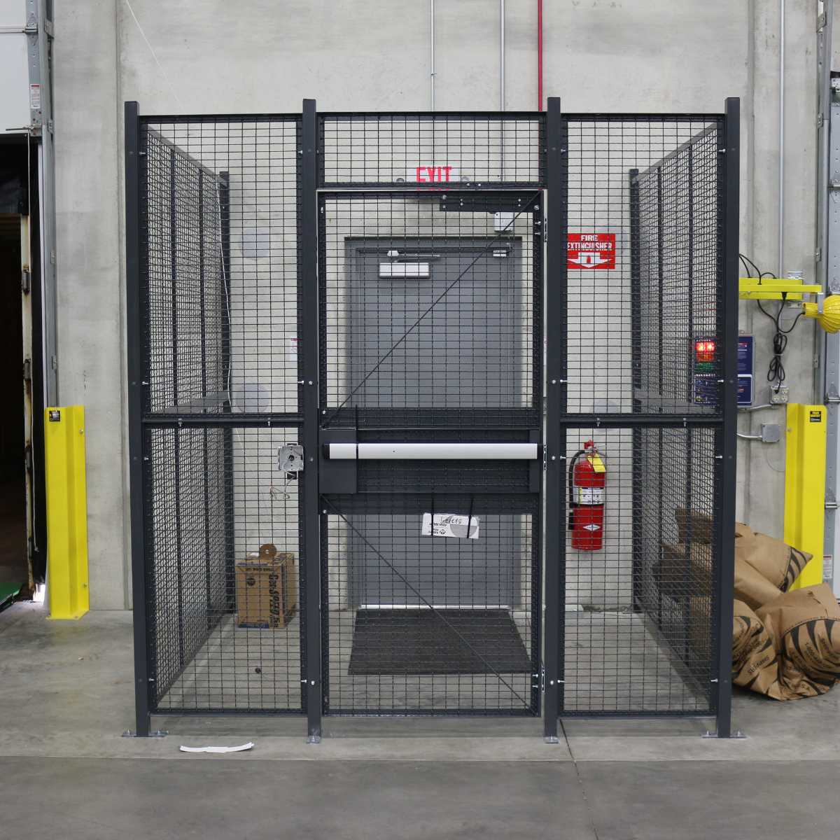 grey 3-panel driver cage with security door at building entrance